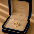 Gold heart necklace in a 'Embellish Gold Jewelry & Diamond' box on a beige surface