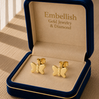 Gold butterfly earrings in a 'Embellish Gold Jewelry & Diamond' box on a wooden surface.