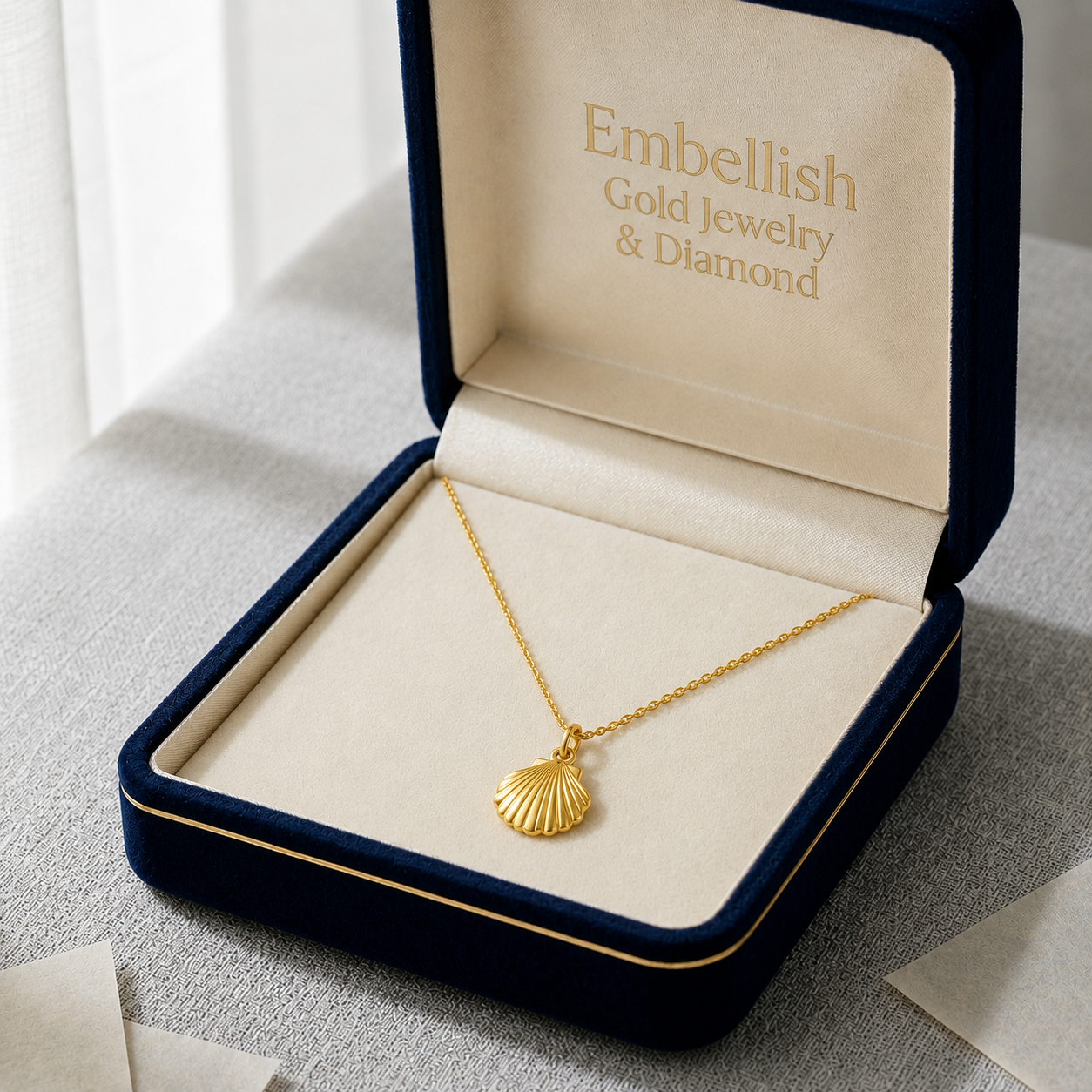 Gold necklace with shell pendant in an 'Embellish Gold Jewelry & Diamond' box.